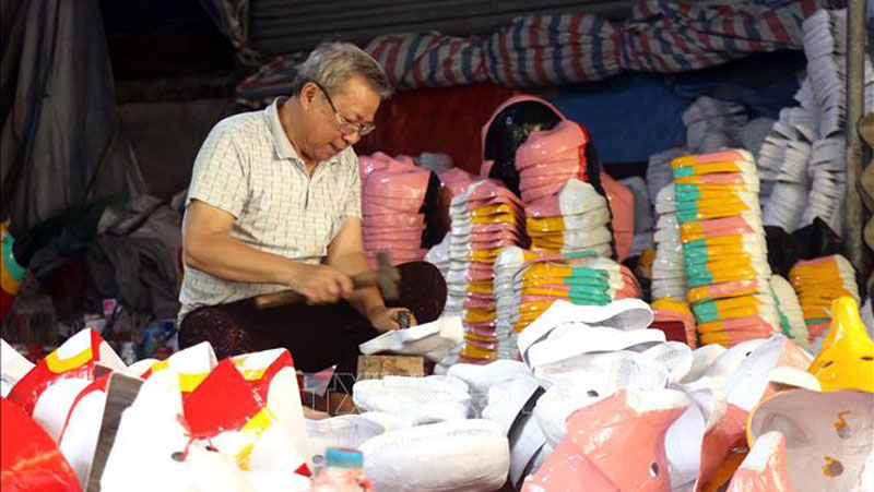 Gia đình ông Vũ Huy Đông là một trong ít hộ tại thôn Ông Hảo giữ được nghề làm mặt nạ giấy bồi. Ảnh: Mai Ngoan/TTXVN