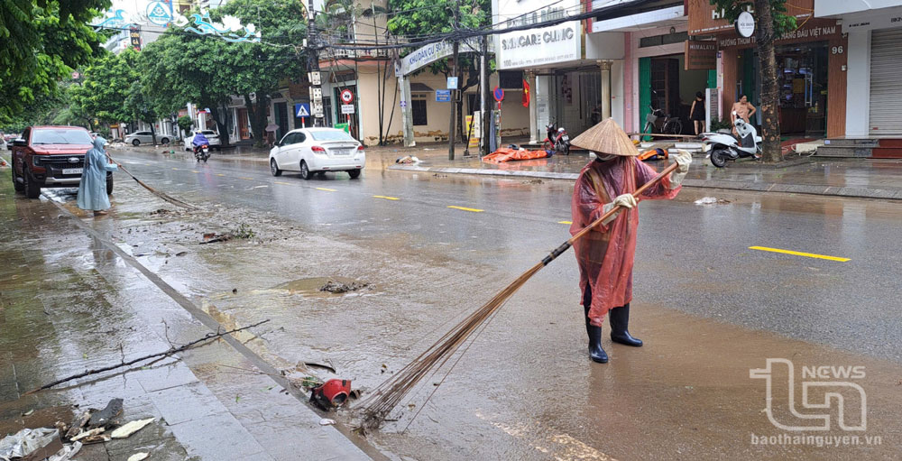 Công nhân Công ty Môi trường và công trình đô thị Thái Nguyên quét gom rác thải sau khi nước rút trên đường Minh Cầu.