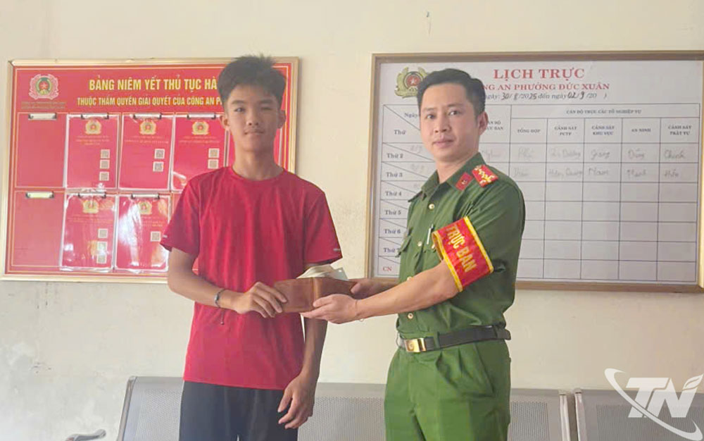 Cháu Vũ Thanh Tùng mang chiếc ví đến Công an phường Đức Xuân để trả lại cho người bị mất.