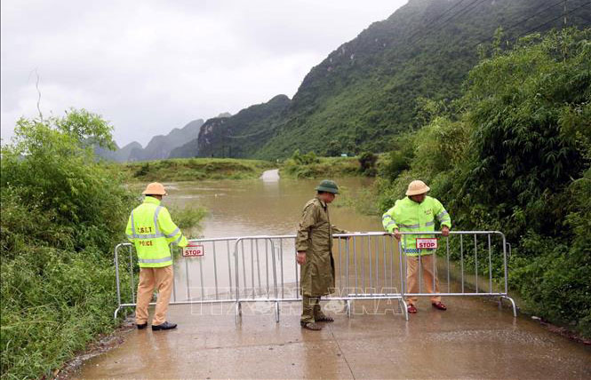 Lực lượng Cảnh sát giao thông đặt gác chắn tại khu vực ngầm tràn bị ngập ở xã Phong Nha. Ảnh minh họa: TTXVN