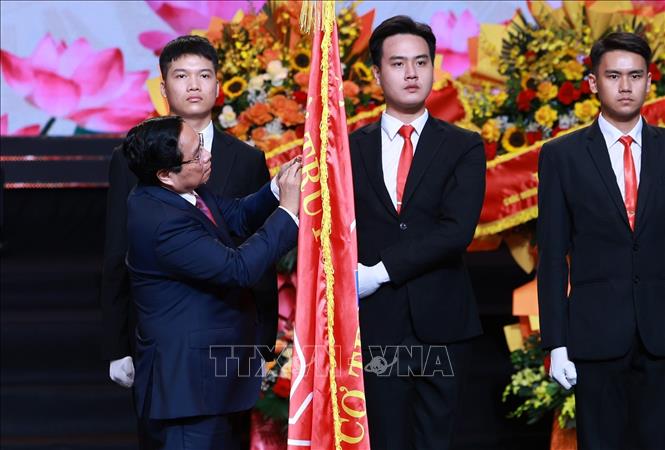 Thủ tướng Phạm Minh Chính gắn Huân chương Hồ Chí Minh lên Cờ truyền thống của Đài Tiếng nói Việt Nam.