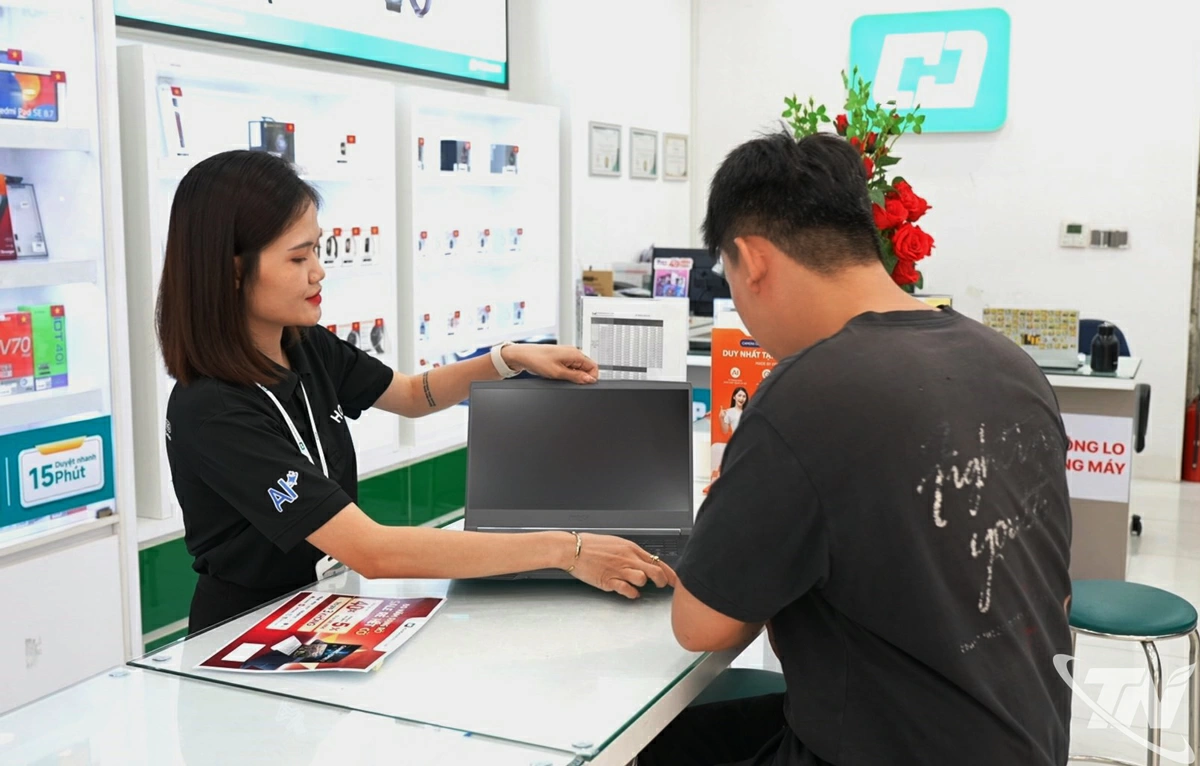 Nhân viên cửa hàng Hoàng Hà Mobile tư vấn sản phẩm laptop cho khách hàng.