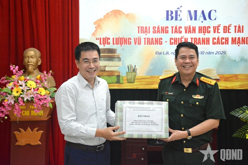 Lãnh đạo Nhà xuất bản Quân đội nhân dân (bên phải) trao bản thảo cho lãnh đạo Trung tâm Hỗ trợ sáng tác văn học nghệ thuật.