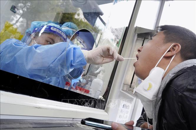 Nhân viên y tế lấy mẫu xét nghiệm COVID-19 cho người dân tại Bắc Kinh, Trung Quốc ngày 12/10/2022. Ảnh: Kyodo/TTXVN