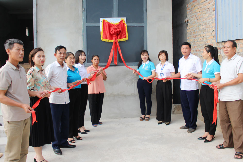 Các đại biểu kéo băng gắn biển công trình nhà Mái ấm tình thương cho gia đình bà Đặng Thị Thao.
