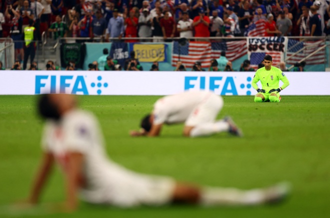 Cầu thủ Iran đổ gục xuống sân sau trận thua sát nút trước Mỹ. Ảnh: Reuters.