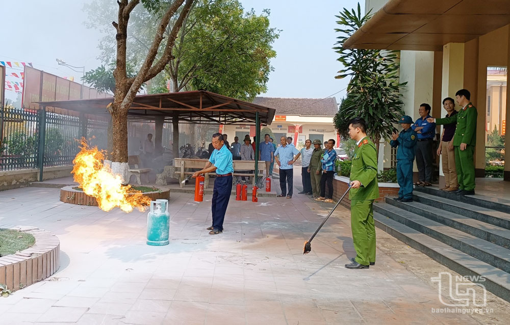 Công an xã Hà Châu hướng dẫn người dân thực hành sử dụng bình chữa cháy.
