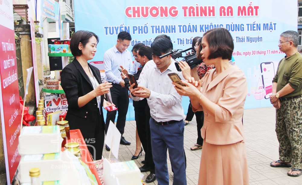 Người dân thanh toán bằng phương thức quét mã QR tại buổi ra mắt tuyến phố văn minh đô thị, không dùng tiền mặt trên địa bàn thị trấn Đu (Phú Lương).