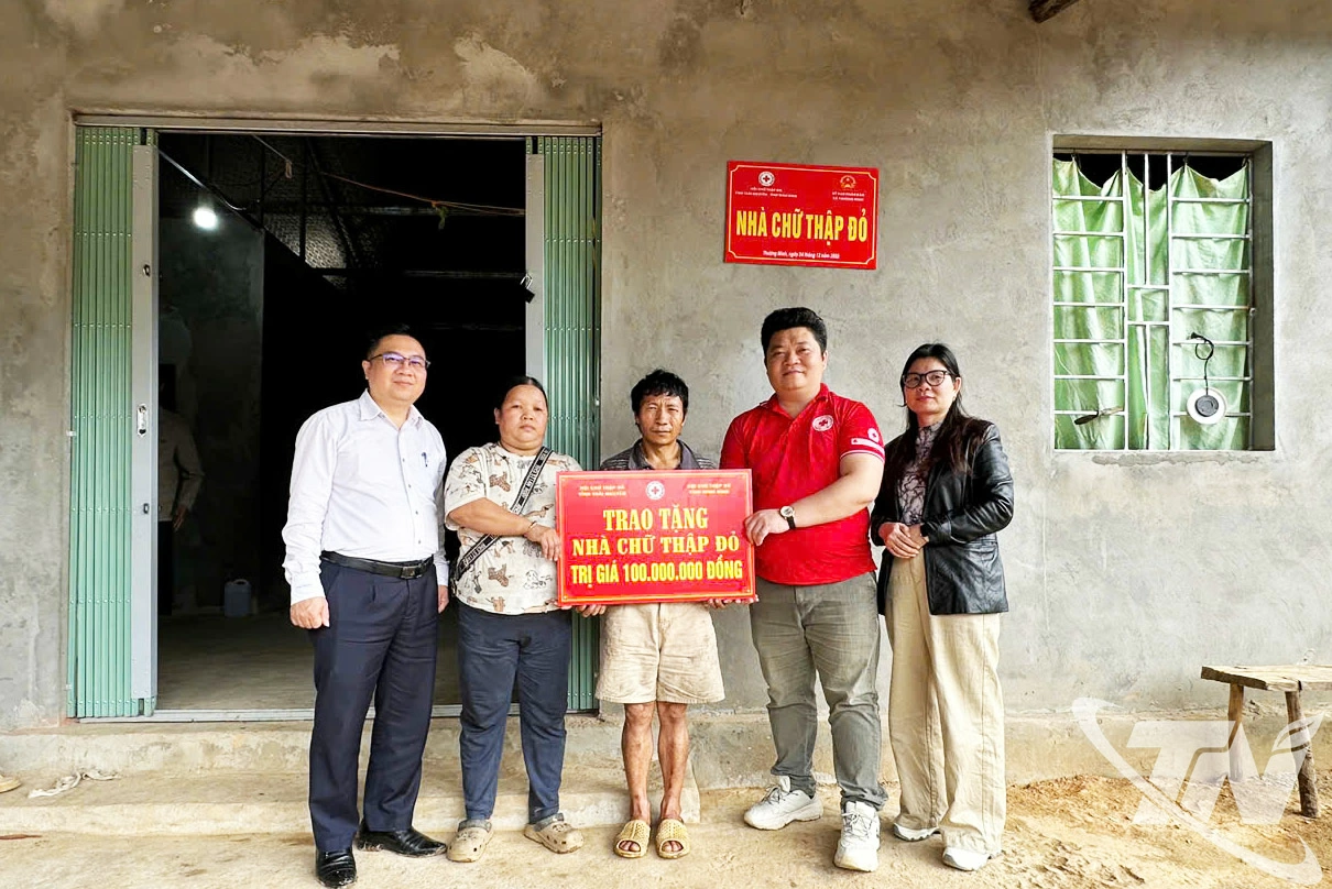 Đại diện lãnh đạo Hội Chữ thập đỏ tỉnh và xã Thượng Minh trao tặng số tiền 100 triệu đồng hỗ trợ làm nhà cho gia đình ông Dương Văn Kinh, thôn Mỹ Vy.