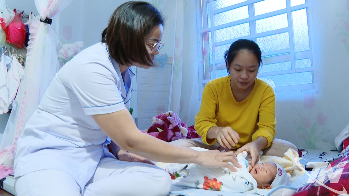 Cán bộ y tế đến tận nhà hướng dẫn biện pháp chăm sóc con và mẹ sau sinh cho người dân ở thôn Khau Ca (xã Cẩm Giàng).